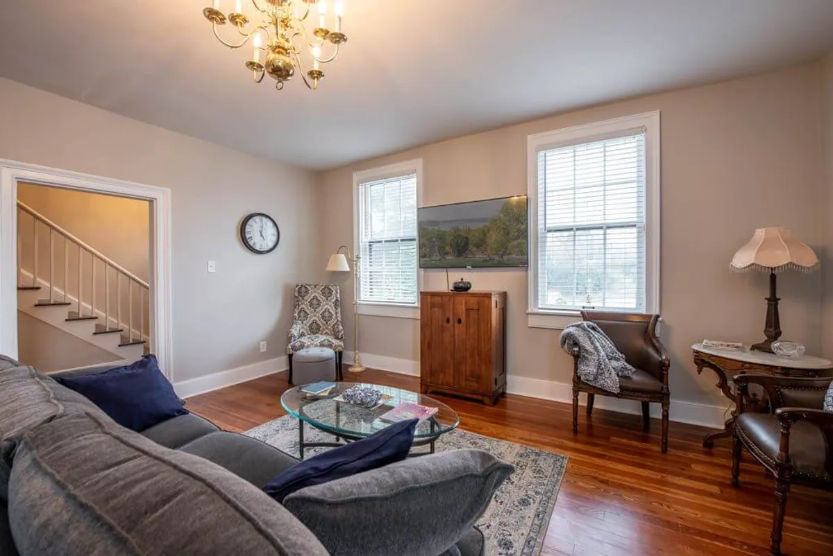 A living area with a plush sofa, glass coffee table, comfortable armchair, and vibrant art. The setting is perfect for socializing, relaxing, or recounting the evening's fun with friends, echoing the lively spirit of the downtown district.