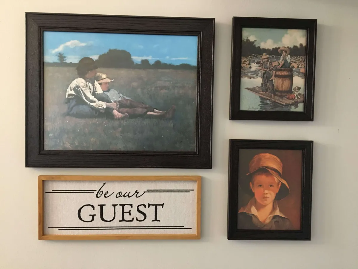 A cozy corner adorned with nostalgic paintings of children and landscapes, plus a cheery welcome sign. The scene suggests a communal atmosphere where guests can gather and share stories after an exciting day or night out.